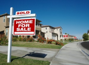 Home For Sale Signs & One Sold in Front of New Homes